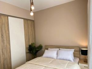 a bedroom with a bed with white sheets and a plant at Lovely 1 Bedroom apt. At Mangroovy residence with free access to the Beach and Pools in Hurghada