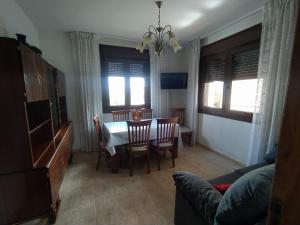 - un salon avec une table à manger et des chaises dans l'établissement Apartamento en SANXENXO Planta alta, à Sanxenxo