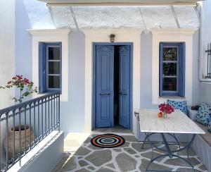 a blue door on a white house with a table at Little Symi House in Symi