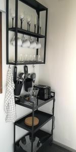 a black shelf with wine glasses and dishes on it at Cosy studio near by AirPort, 2min from train! in Vantaa