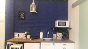 cocina con encimera con microondas en una pared azul en Cozy Rooms - BAÑERA HIDROMASAJE, en Valencia