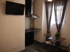 una pequeña cocina con encimera y mesa en una habitación en Cozy Rooms - BAÑERA HIDROMASAJE, en Valencia