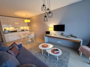 ビストシツァ・クウォツカにあるCzarna Góra Livigno 2のリビングルーム(ソファ、テーブル付)、キッチンが備わります。