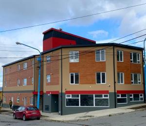 a red car parked in front of a building at Happy Guest Apart 50 in Ushuaia