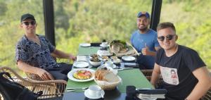 a group of people sitting at a table with food at HIDE ELLA Hotel & Resort in Ella