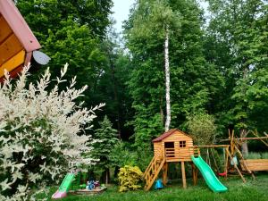 a playground with a tree house and a swing at Domki i Pokoje u Borsa in Lesko