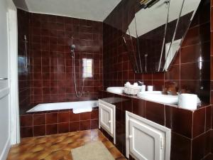 a brown tiled bathroom with two sinks and a tub at Casa Le Cicale in Porto Istana