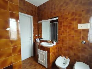 a bathroom with a sink and a toilet and a mirror at Casa Le Cicale in Porto Istana