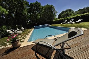 une terrasse avec une chaise et une piscine dans l'établissement L'Appartement des Esclargies, à Rocamadour