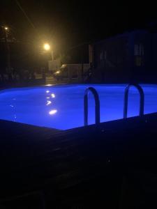 a swimming pool at night with blue illumination at Casa Deac in Sebeş