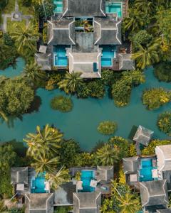 eine Luftaufnahme eines Flusses mit Häusern und Bäumen in der Unterkunft Anantara Mai Khao Phuket Villas in Mai Khao Beach