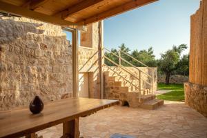 a patio with a wooden bench and a stone wall at Nora's Villa in Riglia