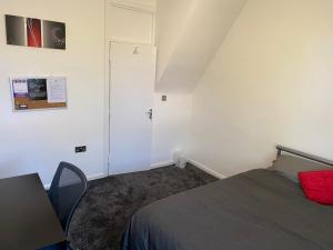 een slaapkamer met een bed, een deur en een tafel bij Waterloo House in Nottingham