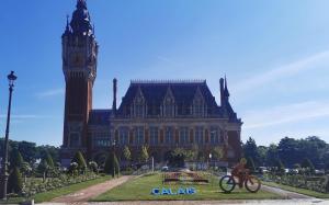 a person riding a bike in front of a large building at Au Kaycedra in Calais +26 photos