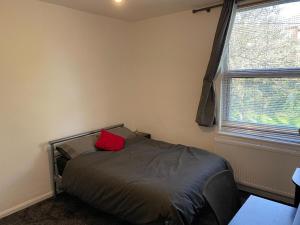 une chambre avec un lit avec un oreiller rouge dessus dans l'établissement Waterloo House, à Nottingham