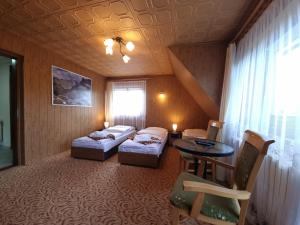 Habitación de hotel con 2 camas y mesa en Apartamenty Rodzinne en Witów