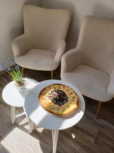 a pizza on a table in a room with two chairs at CHalupa Relax in Dolní Lomná