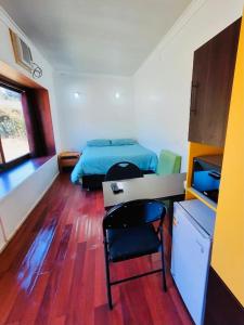 1 dormitorio con cama, escritorio y mesa en Cabañas Habitainer 2, en Pucón
