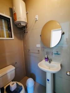 y baño con lavabo, espejo y aseo. en Cabañas Habitainer 2, en Pucón