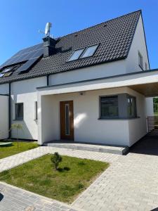 una casa blanca con techo negro en Casa Milo - Trzęsacz en Trzęsacz
