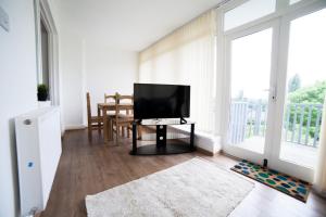 a living room with a flat screen tv and a table at Highfield Road Apartment. in Rowley Regis