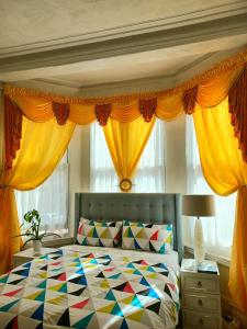 a bedroom with a colorful bed with yellow curtains at Gabriel Guesthouse in Rhyl