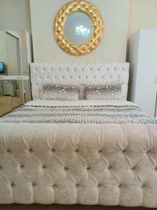 a bedroom with a white bed with a mirror at Gabriel Guesthouse in Rhyl