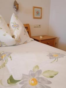 ein Schlafzimmer mit einem weißen Bett mit Blumen darauf in der Unterkunft Appartement Auwald in Forstau