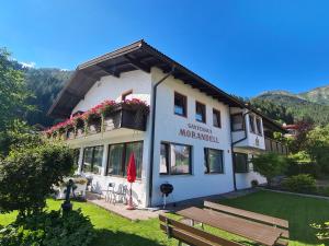 un bâtiment avec un banc devant lui dans l'établissement Gästehaus Morandell, à Fulpmes