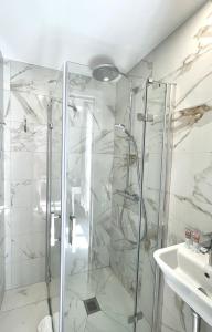 y baño con ducha y lavamanos. en Hotel Normandy en Cap d'Ail