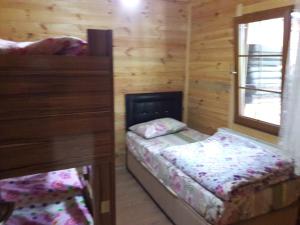 ウズンギョルにあるSarahome Apartの木造キャビン内のベッドルーム1室(ベッド2台付)