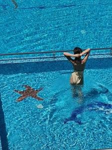 a person in a swimming pool with a star in the water at Апартамент Весела-Хоризонт in Sozopol +6 photos