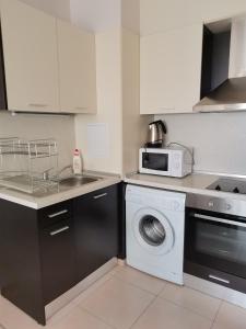 a kitchen with a washing machine and a microwave at Апартамент Весела-Хоризонт in Sozopol