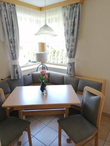 a dining room with a table and chairs and a window at Appartement Auwald in Forstau