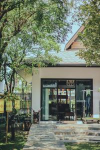 einen vorderen Eingang zu einem Haus mit einer Terrasse in der Unterkunft Le Patta Hotel Chiang Rai SHA Extra Plus in Chiang Rai