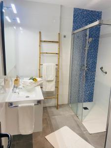 bagno con doccia in vetro e lavandino di Torres Beach ad Arona