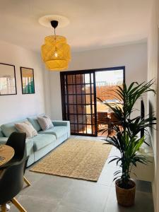 un salon avec un canapé bleu et une plante dans l'établissement Torres Beach, à Arona