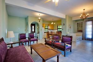 salon z fioletowymi meblami i stołem w obiekcie Vintage country house in Halkidiki w mieście Nea Fokea
