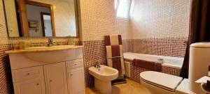 a bathroom with a sink and a toilet and a mirror at An apartment by the sea in Oliva Playa in Oliva