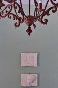 a chandelier hanging over two pictures on a wall at Vintage country house in Halkidiki in Nea Fokea