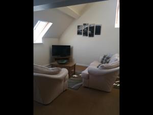 a living room with two couches and a tv at No4 Millhouse Flats in Inverlochy