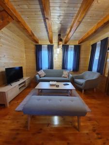 a living room with a couch and a table at FOREST&LAKE COTTAGES in Virpazar