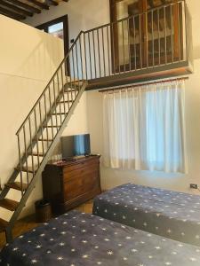 um quarto com uma escada e uma cama e uma cama em Locanda del Glicine em Campagnatico