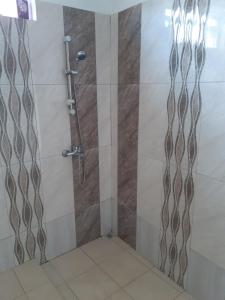 y baño con ducha y puerta de cristal. en Family Residence en Grande Rivière Sud Est