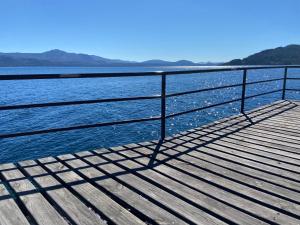 a bench on a pier next to a body of water at Costa Brava Apart Hotel & Suites in San Carlos de Bariloche
