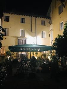 a large umbrella in front of a building at night at Al Cardinale Rooms & Studios in Lucca