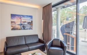 a living room with a leather couch and a chair at Prora Solitaire Panorama 07 in Binz