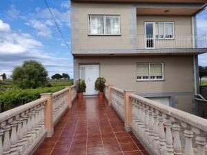 Una pasarela que conduce a una casa con balcón en A Grenla Entre Viñedos (Cambados), en Cambados