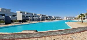 a large swimming pool in front of a building at Plage Mountain View in El Alamein