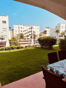 a patio with a table and a lawn with buildings at Tamuda Bay- Alcudia Smir - Fnideq in Fnidek